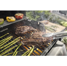 Barbecue avec steaks, asperges et poivrons farcis