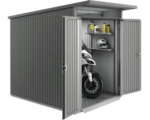 Abri de jardin métallique avec portes ouvertes, contenant une moto, des étagères avec des récipients et un casque.