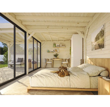 Chambre lumineuse avec murs en bois, lit et portes de terrasse.