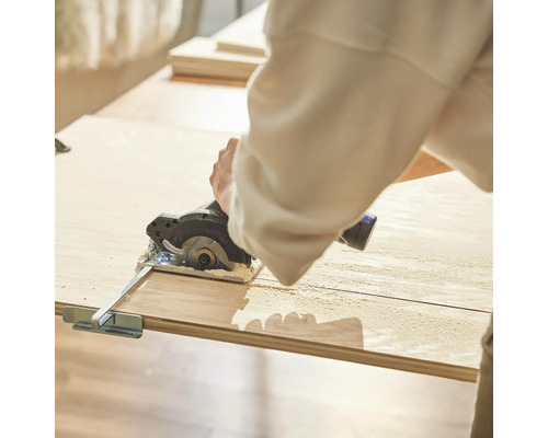 Personne coupant une planche de bois avec une scie circulaire