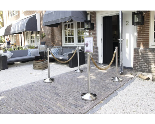 Eingangsbereich mit Absperrpfosten mit Seil und Sitzgelegenheiten vor einem Gebäude