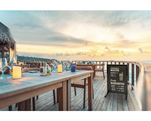 Restaurantterrasse mit Tischen, Stühlen und einer Menütafel mit Getränkeangebot