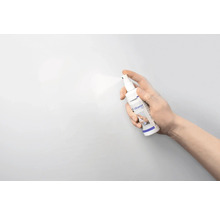 Eine Hand sprüht Legamaster Board Cleaner auf eine Oberfläche.