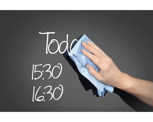 Hand wischt Tafel mit einem Tuch sauber