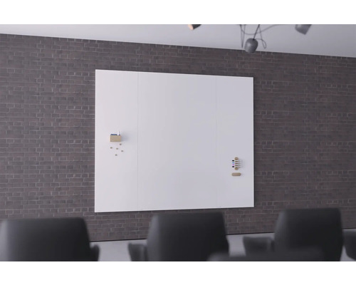 Große, weiße Schreibtafel an einer Ziegelwand in einem Büro.