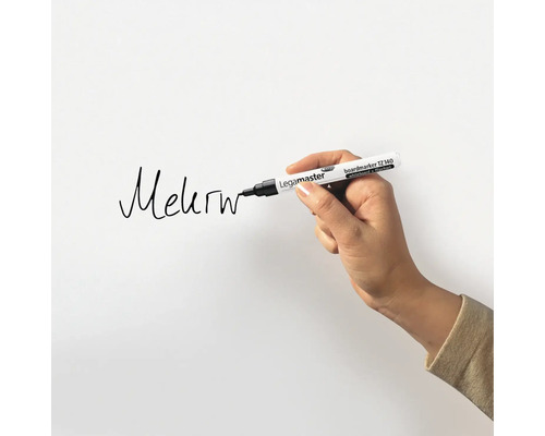 Eine Hand schreibt mit einem Legamaster Boardmarker auf eine weiße Oberfläche.