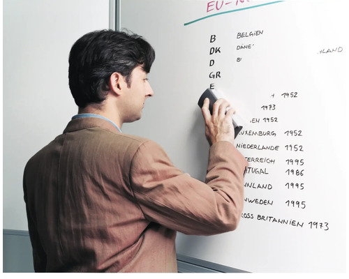 Ein Mann wischt eine Whiteboard-Tafel mit einem Schwamm ab.