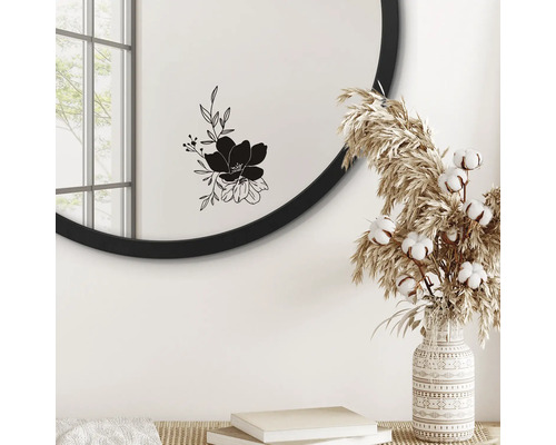 Runder Spiegel mit Blumenmotiv, Vase mit Trockenblumen und Bücher auf einem Tisch