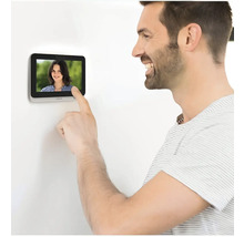 Un homme utilise un interphone avec écran.