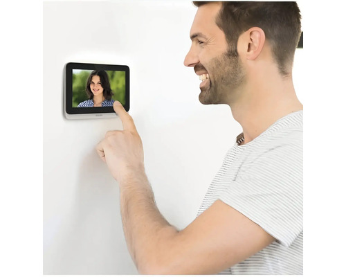 Un homme utilise un interphone avec écran.