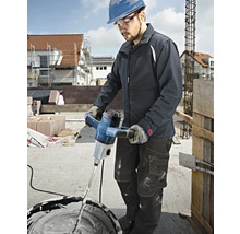 Un artisan utilise un mélangeur à mortier Bosch pour mélanger du plâtre sur un chantier de construction.