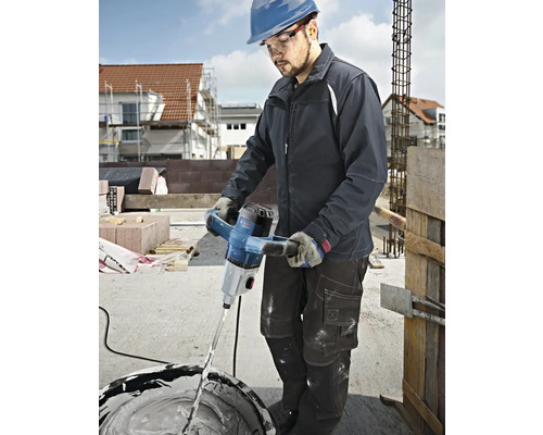 Un artisan utilise un mélangeur à mortier Bosch pour mélanger du plâtre sur un chantier de construction.