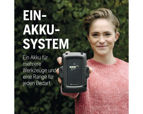 Femme tenant une batterie Husqvarna BLi20 devant la caméra
