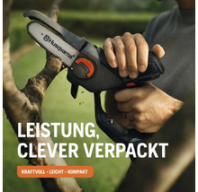 Eine Person schneidet einen Ast mit einer Akku-Astsäge von Husqvarna.