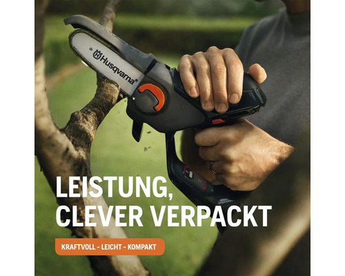 Une personne coupe une branche avec une scie à élaguer sans fil Husqvarna.