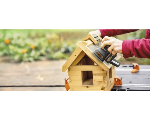 Une personne ponce un nichoir à l''aide d''une ponceuse vibrante de marque WORX.