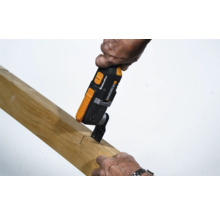 Eine Person benutzt ein Multifunktionswerkzeug zum Schneiden eines Holzstücks.