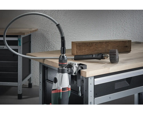 Bohrmaschine mit montierter flexibler Welle und Schleifwerkzeug auf einer Werkbank