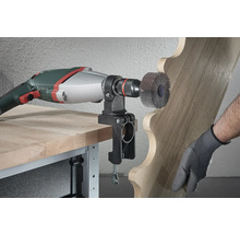 Outil électrique avec brosse abrasive et pièce en bois sur un établi