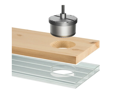 Scie cloche perçant un trou dans une planche de bois au-dessus d''une plaque alvéolaire