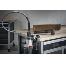 Perceuse avec arbre flexible et accessoires sur un établi