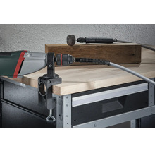 Perceuse avec serre-joint de table et arbre flexible montés sur un établi.