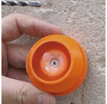 Gros plan d''une personne travaillant avec une perceuse et un cache anti-poussière orange