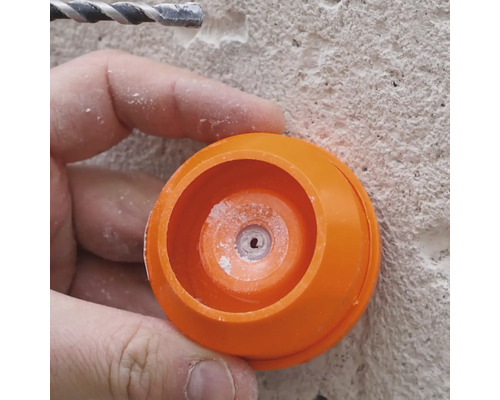 Gros plan d''une personne travaillant avec une perceuse et un cache anti-poussière orange