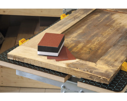 Schleifklotz und Schleifpapier auf einem Holztisch.