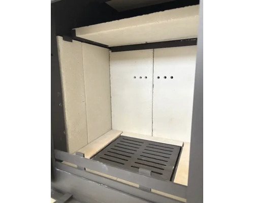 Intérieur d'un poêle avec revêtement de foyer et grille en fonte