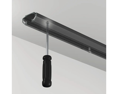 Montage einer Gardinenschiene mit Schraubendreher an der Decke.