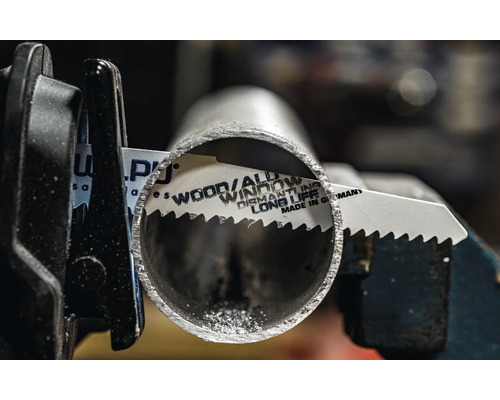 Lame de scie à métaux coupant un tube métallique dans un support