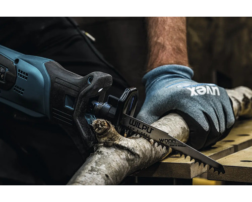 Une personne scie une branche avec une scie sabre électrique et une lame de scie Wilpu.