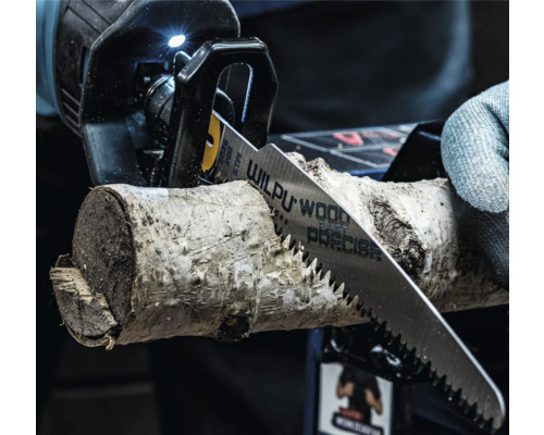 Scie sabre coupant un morceau de bois, gros plan.