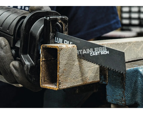 Eine Säbelsäge schneidet ein Metallrohr in einem Schraubstock.