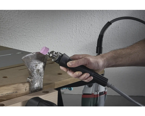 Eine Person schleift eine Axt mit einem Schleifwerkzeug.