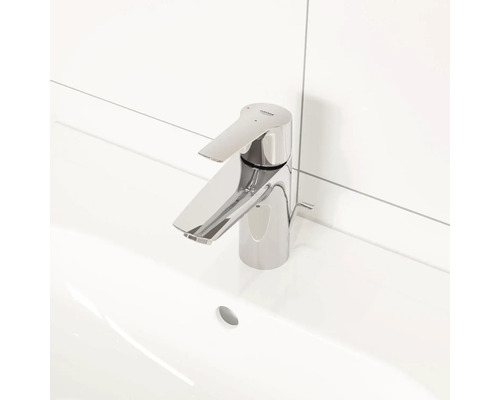 Waschtischarmatur aus Metall mit Grohe Logo auf einem weißen Waschbecken