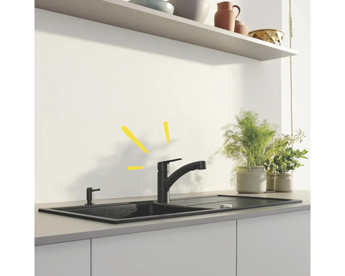 Évier avec robinet et distributeur de savon dans une cuisine lumineuse.