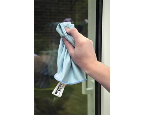 Person reinigt Fenster mit einem Microfasertuch der Marke Unger