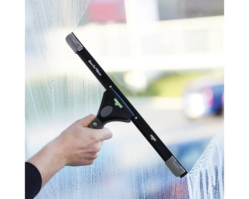 Fensterwischer mit Hand bei der Reinigung einer Fensterscheibe