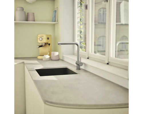 Küchenszene mit Spüle und Armatur auf einer Arbeitsplatte vor einem Fenster