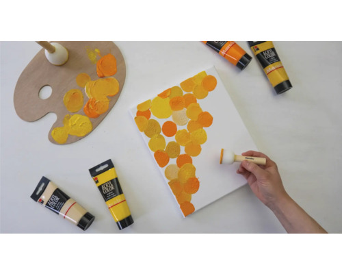 Leinwand wird mit Acrylfarben und einem Farbtupfer bemalt, um ein abstraktes Muster zu erzeugen. Farben, Palette und Pinsel sind ebenfalls vorhanden.