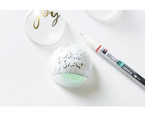 Boules de Noël décorées et un stylo.