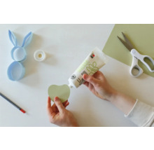 Scène de bricolage avec colle, ciseaux, crayon et papier pour un projet de Pâques