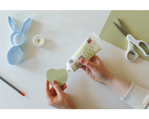 Scène de bricolage avec colle, ciseaux, crayon et papier pour un projet de Pâques