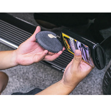 Person trägt Autopolitur auf einen Applikator auf