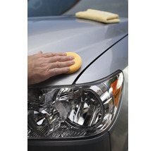 Autopflege: Eine Person poliert ein Auto mit einem Schwamm.