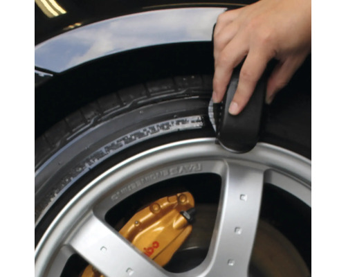 Reifenreinigung mit Bürste an einem Auto