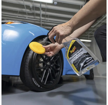 Anwendung von Reifenspray auf ein Autorad mit Applikationsschwamm.