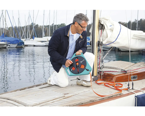 Mann hockt auf einem Boot und benutzt einen Schlauchwagen.